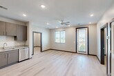 Located at 900 E Main St in Chattanooga, TN, this modern 2-bedroom, 2-bathroom residence offers a well-designed single-level layout with clean contemporary finishes throughout. Light hardwood-style flooring flows seamlessly across every room, complementing the neutral color palette and dark door and baseboard trim accents.

The open-concept kitchen and living area serves as the heart of the unit. The kitchen is outfitted with stainless steel appliances—including a refrigerator, range, microwave, and dishwasher—paired with granite countertops and taupe cabinetry offering ample storage. A ceiling fan, recessed lighting, and access to a private balcony make the living area bright and functional. Windows with blinds invite natural light and outdoor views of the surrounding Chattanooga landscape.

Both bedrooms are well-proportioned and bathed in natural light from window views. Each bedroom connects to its own closet, featuring built-in wire shelving systems for organized storage. The two bathrooms mirror the unit's modern aesthetic, with granite-topped vanities, gray cabinetry, and light tile flooring. One bathroom includes a soaking tub and shower combination, while the other features a walk-in shower. A dedicated laundry area rounds out the practical offerings of this thoughtfully laid-out residence.