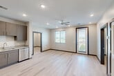 Located at 900 E Main St in Chattanooga, TN, this modern 2-bedroom, 2-bathroom residence offers a well-designed single-level layout with clean contemporary finishes throughout. Light hardwood-style flooring flows seamlessly across every room, complementing the neutral color palette and dark door and baseboard trim accents.

The open-concept kitchen and living area serves as the heart of the unit. The kitchen is outfitted with stainless steel appliances—including a refrigerator, range, microwave, and dishwasher—paired with granite countertops and taupe cabinetry offering ample storage. A ceiling fan, recessed lighting, and access to a private balcony make the living area bright and functional. Windows with blinds invite natural light and outdoor views of the surrounding Chattanooga landscape.

Both bedrooms are well-proportioned and bathed in natural light from window views. Each bedroom connects to its own closet, featuring built-in wire shelving systems for organized storage. The two bathrooms mirror the unit's modern aesthetic, with granite-topped vanities, gray cabinetry, and light tile flooring. One bathroom includes a soaking tub and shower combination, while the other features a walk-in shower. A dedicated laundry area rounds out the practical offerings of this thoughtfully laid-out residence.