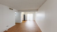 Located at 2705 Windswept Cove in Austin, TX 78745, this single-floor, one-bedroom, one-bathroom home offers a practical and well-organized layout across a comfortably sized footprint. Warm wood-look flooring runs throughout the living spaces, providing a cohesive and inviting aesthetic.

The living room is bright and open, featuring a textured ceiling and a dedicated entry door that creates a clear sense of arrival. A ceiling fan with a light fixture adds both comfort and functionality to the space. A large sliding glass door dressed with vertical blinds allows natural light to filter in while offering access to the outdoors.

The spacious primary bedroom continues the wood-look flooring and includes a ceiling fan, a visible HVAC vent for climate control, and access to an electrical panel conveniently located nearby. An adjacent closet provides dedicated storage space.

The bathroom is cleanly appointed with a wide vanity topped with a light-toned countertop, an under-mount sink, and cream-colored cabinetry below. A large wall mirror with overhead vanity lighting enhances the sense of space, while a towel bar and clean white walls complete the functional design.

Overall, this home presents a clean, neutral palette throughout, making it a versatile and move-in ready residence in South Austin.