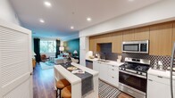 Located at 2727 Mainplace Dr in Santa Ana, CA, this thoughtfully designed two-bedroom, one-bathroom residence offers a modern and functional living experience across a single floor. The open-concept layout seamlessly connects the kitchen, dining, and living areas, creating a cohesive and inviting atmosphere throughout.

The kitchen is a standout feature, showcasing a striking black hexagonal tile backsplash, warm wood upper cabinetry, crisp white lower cabinets, and a full suite of stainless steel appliances including a gas range, dishwasher, microwave, and refrigerator. A peninsula with bar seating provides an ideal space for casual dining and entertaining.

The living area benefits from natural light streaming through large windows dressed with floor-length drapes, with access to an outdoor area. Rich wood-tone flooring flows throughout the main living spaces, adding warmth and continuity.

The spacious primary bedroom offers a serene retreat with a window view, soft carpeting, and a dedicated walk-in closet equipped with wire shelving and hanging storage. The second bedroom provides additional flexibility for guests or a home office.

The bathroom is clean and contemporary, featuring large-format white tile in the shower-tub combo, wood-look flooring, and a bright, minimalist aesthetic. Recessed lighting throughout the home enhances the modern, well-lit ambiance.