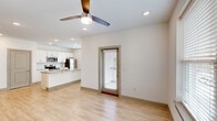 This single-story, 2-bedroom, 2-bathroom residence in Gonzales, Louisiana offers a clean, modern design highlighted by light hardwood-style flooring and crisp white walls throughout. The open-concept living and dining area flows naturally into the kitchen, where white shaker-style cabinetry, granite countertops, and a full suite of stainless steel appliances — including a refrigerator, electric range, microwave, and dishwasher — create a functional and attractive space. A central island with a double-basin sink and additional counter space adds practicality. Recessed lighting and natural light from multiple windows keep the interior bright and welcoming.

A light-filled hallway connects the two bedrooms, each featuring ceiling fans, windows with exterior views, and ample room for furnishings. The primary bathroom includes a granite-topped vanity with white cabinetry and access to a walk-in closet with built-in shelving. The second bathroom features a full tub-shower combination. Both bathrooms maintain the same clean, neutral aesthetic found throughout the unit. The consistent use of light tones, recessed lighting, and low-maintenance flooring gives the entire space a cohesive, contemporary feel.