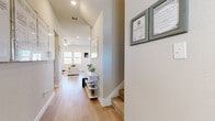 This two-story home in Temple, TX offers a well-designed layout spread across two floors, with the majority of the living space on the main level. The open-concept main floor seamlessly connects the living room, dining area, and kitchen, creating an inviting and functional hub for daily life. The kitchen is a standout feature, boasting crisp white shaker cabinetry, quartz countertops, stainless steel appliances, a subway tile backsplash, and a large center island with bar seating — ideal for both cooking and entertaining. The dining area is bathed in natural light from multiple windows with views of the surrounding neighborhood. The living room features vaulted ceilings, a ceiling fan, and large windows that fill the space with bright, airy light. Light wood-tone flooring flows throughout the main level, complementing the neutral color palette. The generously sized primary bedroom offers a serene retreat, while additional bedrooms on the upper floor provide flexibility and privacy. The bathrooms are finished with white vanities and clean, modern fixtures. A dedicated laundry room, two closets, and multiple hallways round out the practical layout. This home combines modern finishes with a bright, comfortable atmosphere throughout.