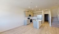 Located at 7848 Rustic Trail Loop in Colorado Springs, Colorado, this two-story home offers 1,370 square feet of living space across two floors, with 510 sq ft on the ground level and 860 sq ft on the upper level. The home features 3 bedrooms, 3 bathrooms, and a consistent design language of clean white walls and light-toned luxury vinyl plank flooring throughout.

The kitchen is appointed with gray shaker-style cabinetry, white quartz countertops, stainless steel appliances including an electric range and over-the-range microwave, and a stainless steel sink. Bedrooms are bright and airy, benefiting from large windows that frame sweeping mountain and open landscape views characteristic of the Colorado Springs area. The primary bedroom spans 210 sq ft and connects directly to a private en-suite bathroom featuring gray vanity cabinetry with a white countertop and a glass-enclosed walk-in shower. A spacious walk-in closet with built-in double clothing rods provides ample storage.

The bathrooms maintain a clean, modern aesthetic with glass-door shower enclosures and light flooring. A dedicated laundry room houses a full-size Whirlpool washer and dryer. The attached garage features an automatic opener and concrete flooring, offering secure parking and additional storage space.