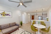 Located at 4650 Washington Ave in New Orleans, this modern 2-bedroom, 2-bathroom unit offers a thoughtfully designed open-concept layout with clean lines and contemporary finishes throughout. Light wood-style flooring flows seamlessly across the entire space, complemented by crisp white walls and recessed lighting that create a bright, airy ambiance.

The combined kitchen, dining, and living area serves as the heart of the home. The kitchen is outfitted with light wood cabinetry, stainless steel appliances including a refrigerator, range, microwave, and dishwasher, and a spacious island with a quartz countertop and double sink, illuminated by sleek pendant lights. The adjacent dining and living areas are bathed in natural light from large windows fitted with blinds, and ceiling fans enhance comfort throughout.

Both bedrooms are generously proportioned, each featuring ceiling fans, ample closet space, and a calm, neutral palette. The primary bedroom is notably spacious and includes its own walk-in closet and en-suite access. The two bathrooms are finished in a modern style, with one showcasing a large glass-enclosed walk-in shower with white subway tile and light wood vanity cabinetry. The unit also includes in-unit laundry and a hallway connecting all spaces efficiently.