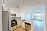 Located in Calgary's vibrant Beltline neighbourhood, this one-bedroom, one-bathroom unit at 805 14 Ave SW offers a well-designed open-concept layout with a clean, contemporary aesthetic throughout. Light hardwood-style flooring flows seamlessly across the main living areas, complementing the crisp white walls and bright, airy atmosphere.

The kitchen is a standout feature, equipped with a full suite of stainless steel appliances including a refrigerator, electric range, built-in microwave, and dishwasher. White cabinetry with ample storage is paired with light stone countertops and a grey tile backsplash. A peninsula with an undermount sink and elegant pendant lighting connects the kitchen to the open living area, making it ideal for both everyday living and entertaining.

The living room benefits from floor-to-ceiling windows that frame expansive city views and flood the space with natural light. The bedroom is a comfortable, well-proportioned room with its own window offering additional city views. The bathroom features a full soaker tub and shower combination with clean white tile surround and chrome fixtures. Additional conveniences include in-unit laundry and an impressive five closets, providing generous storage throughout. The unit offers a practical and modern urban living experience.