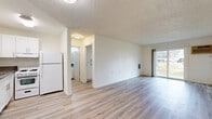 Located at 1560 Yosemite Dr in the Eagle Rock neighborhood of Los Angeles, CA, this one-bedroom, one-bathroom unit offers a practical and well-organized single-floor layout. The living room is the largest area of the unit, featuring light wood-look plank flooring, crisp white walls, and a textured ceiling. A sliding glass door floods the space with natural light and provides a view of the surrounding greenery, while a wall-mounted AC unit ensures year-round comfort. The open sightline from the living area extends into the compact kitchen, which is outfitted with white cabinetry, a wall-mounted light fixture, and a countertop sink — offering an efficient and clean workspace. The bedroom is a well-proportioned private retreat with its own window fitted with blinds that allow for natural light and privacy control. Light wood-look flooring continues throughout, maintaining a cohesive aesthetic. The bathroom features a combination shower and bathtub with multiple grab bars for added safety and accessibility, complemented by a vanity with a speckled countertop and matching light wood-look flooring. Throughout the unit, the clean white palette and consistent flooring create a bright, neutral atmosphere well-suited for comfortable everyday living.