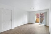 This 2-bedroom, 2-bathroom residence is thoughtfully laid out across a single floor, offering a clean and functional living environment throughout. The kitchen is a standout feature, designed with white cabinetry, ample upper and lower storage, a gas range, built-in microwave, and a full-size refrigerator. A peninsula counter defines the kitchen's boundary and provides additional prep and seating space, while light wood-look flooring ties the kitchen and adjacent areas together seamlessly. The living room benefits from natural light and features a sliding glass door that opens to a private balcony, offering pleasant outdoor views. Neutral-toned walls and wood-style flooring give the living space a bright, airy feel. Both bedrooms are carpeted and well-sized, with the primary bedroom featuring a dedicated walk-in closet outfitted with wire shelving for organized storage. A hallway connects the bedrooms to the rest of the home, providing a natural separation between living and sleeping areas. Each bathroom includes a full tub-shower combination with chrome fixtures and wood-look tile flooring, maintaining a consistent, clean aesthetic. The dedicated closet adds further storage utility, rounding out a practical and comfortable floor plan.
