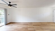 Located at 2703 Windswept Cove in Austin, TX 78745, this well-appointed one-bedroom, one-bathroom home offers a thoughtfully designed single-floor layout. Warm wood-look flooring flows consistently throughout the space, tying each room together with a clean, cohesive aesthetic.

The combined kitchen and living area forms the heart of the home. The kitchen features white shaker-style cabinetry with gold hardware, a stainless steel appliance suite including a dishwasher and refrigerator, a single-basin sink, and light countertops that complement the bright, airy atmosphere. A sliding glass door adjacent to the kitchen connects the space to the outdoors, filling the area with natural light.

The living room is open and inviting, accented by a ceiling fan overhead and crisp white walls that maximize the sense of space.

The bedroom is generously sized, complete with a sleek five-blade ceiling fan with integrated lighting and a sliding glass door that opens onto a private balcony with outdoor views — a standout feature offering both natural light and fresh air. A dedicated closet provides practical storage.

The bathroom is a refined retreat, featuring a soaking tub and shower combination surrounded by large-format marble-look tile in white with elegant veining, adding a touch of luxury to the space.