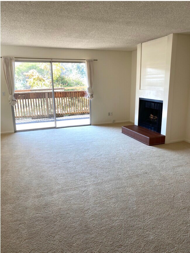 Large living/dining area with fireplace and easy access to a deck. - 50 Corte Real