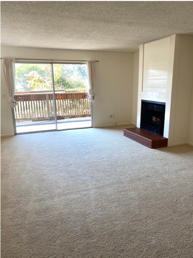Large living/dining area with fireplace and easy access to a deck. - 50 Corte Real