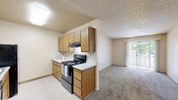 Located at 4121 Dale Rd in Modesto, California, this single-floor, two-bedroom, one-bathroom unit offers a functional and straightforward layout. The living area is carpeted and features a sliding glass door that opens to a private balcony, allowing natural light to fill the space and offering outdoor views. Adjacent to the living area, the kitchen is equipped with warm wood cabinetry and a countertop workspace, providing practical storage and prep space.

Both bedrooms are carpeted and finished with neutral-toned walls and textured ceilings. Each room features windows dressed with vertical blinds, letting in natural light while maintaining privacy. The bedrooms are served by two closets, each carpeted and outfitted with hanging rods and shelving for organized storage. Six-panel doors connect the bedrooms to the shared hallway and bathroom.

The bathroom is well-appointed with a full tub and shower combination, a wood-vanity with ample drawer storage, a wide countertop with a single sink, and a large mirror with overhead lighting. Tile flooring completes the clean, practical design of the bathroom.

Throughout the unit, the consistent use of warm wood tones, neutral beige walls, and plush carpet creates a cohesive and comfortable living environment suited for everyday living in Modesto, CA.