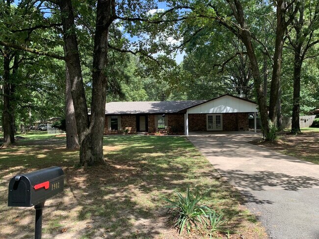 The property is shaded by tall trees so it stays cool in the summer! - 1903 Ginnett Rd