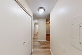 Located at 125 SW Campus Dr in Federal Way, WA, this single-floor, two-bedroom, two-bathroom home offers a well-organized layout with a practical and comfortable design throughout. Light wood-style flooring runs consistently across the living spaces, complemented by neutral warm-toned walls and textured ceilings that add subtle character.

The open combined living and dining area is a central highlight, featuring a wood-burning fireplace with a clean tile surround, a ceiling fan, and a large window that brings in natural light and views of surrounding greenery. This space flows naturally into the kitchen, which is equipped with rich dark wood cabinetry, light countertops, and stainless steel appliances, including a range with an overhead ventilation hood.

A well-lit hallway connects the bedrooms and bathrooms, lined with multiple closets — six in total — offering generous storage throughout. The primary bedroom is spaciously sized and includes a sliding closet door. Both bathrooms feature wood-toned vanity cabinetry, light countertops, and full bathtub-shower combinations with natural light from frosted windows.

Additional practical features include a dedicated laundry area and a private balcony, rounding out this efficiently designed home ideal for everyday living.