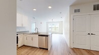 Located on Union Street in New Haven, CT, this thoughtfully designed 3-bedroom, 2-bathroom unit offers a clean, modern aesthetic throughout its single-floor layout. Light-toned hardwood-style flooring flows seamlessly across the living spaces, complementing the bright white walls and creating a cohesive, airy atmosphere.

The kitchen is a standout feature, equipped with white shaker cabinetry, gray quartz countertops, stainless steel appliances, and a peninsula with a built-in sink — ideal for both everyday cooking and entertaining. Recessed lighting and an open layout connect the kitchen to the rest of the living area.

The primary bedroom is a well-proportioned retreat featuring a walk-in closet and direct access to the kitchen area, offering practical convenience. One of the bedrooms includes sliding glass doors that open onto a private balcony overlooking a landscaped courtyard shared with the surrounding building complex. Additional bedrooms provide flexible space with neutral finishes and ample natural light.

Both bathrooms are finished with large-format gray wall tiles, wood-look floor tiles, white vanities with gray countertops, and matte black fixtures. One bathroom features a soaking tub with a shower combo, while the other offers a walk-in shower. The overall design is modern, clean, and functional throughout.