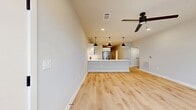 This 530-square-foot single-floor unit at 9520 Whippet Way in Charlotte, NC offers a thoughtfully designed layout that maximizes functionality within a compact footprint. The open-concept kitchen and living area serves as the heart of the unit, featuring light hardwood-style flooring, neutral gray walls, and recessed lighting complemented by a ceiling fan. Large windows fitted with horizontal blinds allow natural light to fill the living space, creating a bright and airy atmosphere.

The kitchen is well-appointed with two-tone cabinetry—white upper cabinets and gray lower cabinets—paired with white quartz countertops and a classic white subway tile backsplash. Stainless steel appliances, including a range, microwave, and French door refrigerator, are standard features. A kitchen island with an undermount sink and a matte black pull-down faucet provides additional prep space, illuminated by a pendant light fixture.

The bathroom includes a tub-shower combination with floor-to-ceiling white tile, matte black fixtures, a vanity with drawers, and hardwood-style flooring. The walk-in closet is equipped with multi-tiered wire shelving and carpeted flooring, offering organized storage. A connecting hallway ties all spaces together efficiently.