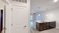 Located at 450 Leclaire St in Davenport, Iowa, this well-appointed one-bedroom, one-bathroom unit offers a thoughtfully designed layout that maximizes every square foot. The open-concept kitchen and living area serves as the heart of the home, featuring rich dark-walnut cabinetry, light granite-style countertops, a peninsula with a built-in sink, pendant lighting, and black appliances including a range and over-the-range microwave. Light wood-look flooring flows throughout the main living areas, enhancing the bright, clean aesthetic. The living room benefits from natural light via a glass-paneled exterior door and an adjacent window, and is topped with a ceiling fan for added comfort. The bedroom is a serene retreat, carpeted for warmth and comfort, with its own ceiling fan, a window overlooking a stone-accented exterior, and convenient access to a dedicated closet. The bathroom is finished in neutral tones with tile-look flooring, a combined tub and shower, and clean white fixtures. A dedicated HVAC vent system and accessible grab bars in the bathroom highlight the unit's practical, modern design. This unit offers a clean, move-in-ready living experience in a contemporary residential setting.