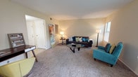 This single-story residence at Stonemill Village offers a well-organized layout designed for comfortable everyday living. The living room serves as the heart of the home, featuring neutral-toned carpet, soft warm walls, and multiple windows that allow natural light to filter in alongside views of surrounding greenery. The open flow connects seamlessly to a dining area, which includes access to an outdoor space through a sliding glass door, enhancing the sense of openness throughout.

The kitchen is efficiently arranged with ample cabinetry, a coil-top range, dishwasher, and a window overlooking the outdoors, providing both functionality and natural light during meal preparation. Tile flooring runs throughout the kitchen and bathroom, while plush carpet lines the living and bedroom areas.

Two carpeted bedrooms each feature windows with outdoor views and offer comfortable accommodations. The full bathroom is fitted with tile flooring, a vanity with storage below, a large mirror, and well-lit overhead fixtures. A dedicated laundry area houses a full-sized washer and dryer with overhead cabinetry, adding practical convenience to the home's overall design.
