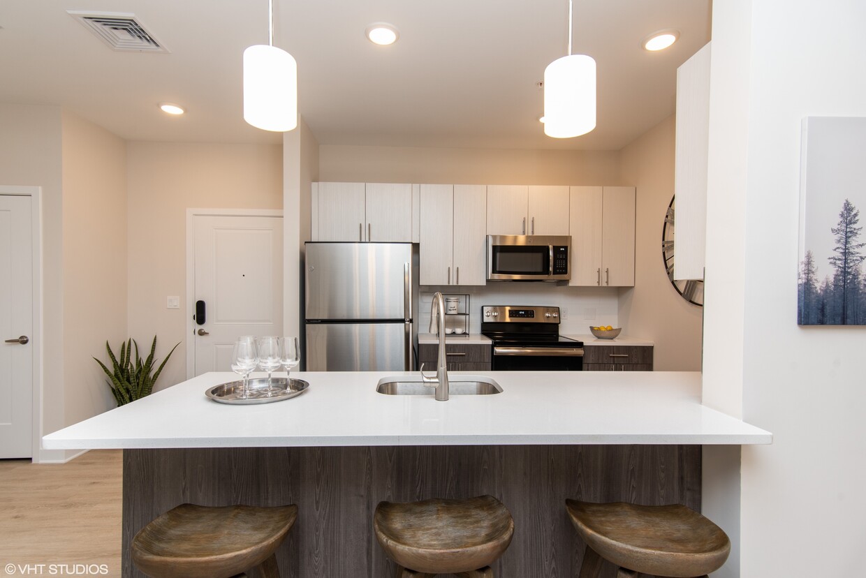 Gorgeous kitchen space with quartz white countertops and stainless steel appliances - The Preserve at Great Pond