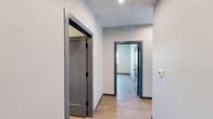 Located at 281 Willow St in Fort Collins, Colorado, this thoughtfully designed single-floor unit offers a clean, modern aesthetic throughout its well-appointed layout. Light wood-look flooring flows continuously through the space, complemented by crisp white walls, bold navy-blue baseboards, and dark gray door frames that add a contemporary contrast to the interior.

The kitchen is a functional highlight, featuring gray cabinetry, granite-style countertops, stainless steel appliances including a refrigerator with ice maker, range, microwave, and dishwasher, along with open shelving for added storage. A large sliding glass door in the kitchen area floods the space with natural light and provides access to an outdoor balcony with views of the surrounding Fort Collins neighborhood.

The unit includes multiple rooms accessible via a central hallway, offering flexible use of space. Each room benefits from light-toned walls and durable flooring. The bathroom is well-equipped with a glass-enclosed walk-in shower featuring matte black fixtures, as well as a separate tub-shower combination. A granite-topped vanity with an undermount sink rounds out the bathroom's refined, modern design.

An entry foyer with a built-in mail slot provides a practical and welcoming transition into the unit, reinforcing its functional, resident-focused design approach.