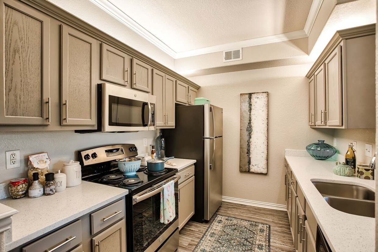 Kitchen featuring all stainless front appliances, large quartz counter tops, and grey cabinets. - Ellery at  Lake Sherwood