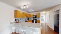 Located at 7500 Redwood Boulevard in Temperance, Michigan, this 2-bedroom, 1-bathroom residence offers a thoughtfully designed single-floor layout that maximizes functionality and comfort. The open-concept kitchen and dining area serves as the heart of the home, showcasing warm honey-toned cabinetry, granite countertops with a coordinating tile backsplash, and black appliances including a range, microwave, and dishwasher. A peninsula with bar seating provides an ideal space for casual dining or entertaining. The living room is bright and inviting, featuring hardwood flooring and a sliding glass door dressed with vertical blinds that floods the space with natural light. The spacious primary bedroom offers carpeted flooring and generous closet space with wire shelving systems for organized storage. The second bedroom is equally well-lit, with a large window, a full closet, and plush carpeting, making it versatile for use as a guest room or home office. The bathroom continues the granite and warm wood cabinetry theme seen throughout the home, featuring a wide vanity with an undermount sink and a large mirror. Consistent neutral tones and clean finishes create a cohesive, move-in-ready atmosphere throughout the residence.