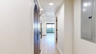 Located on the fifth floor at 1047 Fedora St in Los Angeles, this modern studio unit offers a thoughtfully designed open-concept layout. The main living area is finished with light-toned hardwood flooring that runs throughout, complemented by crisp white walls and recessed lighting that creates a clean, airy atmosphere. A large sliding glass door floods the space with natural light and opens to views of the surrounding Los Angeles cityscape, adding a sense of openness to the compact footprint.

The integrated kitchen is positioned along one wall and features warm wood cabinetry, stainless steel appliances including a refrigerator and range, and a single-basin sink — providing a fully functional cooking space without interrupting the flow of the living area.

The bathroom is efficiently designed with neutral mosaic tile flooring, a walk-in shower with herringbone-patterned wall tile, a wall-mounted vanity with a wood cabinet base, and full-height wood-paneled storage. Recessed lighting overhead keeps the space bright and functional.

Overall, the unit presents a minimalist, contemporary aesthetic with consistent modern finishes, making it a practical and stylish option in the heart of Los Angeles.
