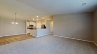 Located on Gilbert Lane in Stow, Ohio, this single-floor residence offers a thoughtfully designed open-concept layout that seamlessly connects the living, dining, and kitchen areas. The kitchen is a standout feature, showcasing white shaker cabinetry, granite countertops, stainless steel appliances including a refrigerator, range, and microwave, and a peninsula with a built-in sink that serves as both a functional workspace and a casual gathering spot. Luxury vinyl plank flooring runs throughout the kitchen and dining areas, while plush carpet adds warmth to the living room and bedrooms. The dining area features vaulted ceilings and an elegant chandelier, contributing to an airy, open ambiance. The generously sized bedroom is carpeted and includes a ceiling fan and a window that allows natural light to filter in. Two full bathrooms are finished with tile flooring and white vanities; one includes a walk-in shower with a glass sliding door, while the other features a full soaking tub and shower combination. Neutral gray tones throughout the home create a clean, modern aesthetic that is both versatile and inviting. Recessed lighting and white trim provide polished finishing details across the entire space.