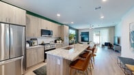 Located in Chandler, AZ, this thoughtfully designed two-bedroom, two-bathroom residence offers a seamless blend of modern aesthetics and functional living across a single floor. Light wood-style flooring flows throughout, creating a cohesive and airy atmosphere.

The open-concept kitchen is a standout feature, showcasing light wood cabinetry that extends to the ceiling, granite countertops, stainless steel appliances, and a central island with a built-in sink — ideal for both cooking and casual dining. An in-unit stacked washer and dryer adds everyday convenience.

The living room is anchored by a bold green accent wall, natural light from a window with blinds, and generous wall space that lends itself well to art display. The space connects fluidly to the kitchen, making it well-suited for entertaining.

The primary bedroom features a ceiling fan, track lighting, and natural light filtered through sheer curtains, complemented by a green accent wall. It includes direct access to an en-suite bathroom with a dual granite vanity and a walk-in closet. The second bedroom is equally well-appointed with a ceiling fan and natural light.

Both bathrooms carry consistent finishes, including granite countertops and light wood cabinetry. A hallway and two closets complete the practical layout of this well-designed Chandler residence.