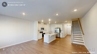 Located at 1010 Pulitzer Ln in Durham, NC, this two-story home offers a well-organized layout across two generously sized floors. The main level features an open-concept kitchen and living area with light wood-tone flooring throughout. The kitchen is equipped with white shaker-style cabinetry, light quartz countertops, a central island with a sink, and stainless steel appliances including a French door refrigerator with ice and water dispenser, electric range, and microwave. Recessed lighting illuminates the space, which also includes a pantry closet and staircase leading to the upper level. The upper floor hosts both bedrooms, two full bathrooms, three closets, and a dedicated laundry room. The spacious primary bedroom features plush carpeting, a tray ceiling, and direct access to a walk-in closet and an en-suite bathroom. The second bedroom is also carpeted and offers ample room with its own closet. Both bathrooms are finished with tile flooring, white vanities, and large mirrors. The laundry room includes a full-size washer and dryer with overhead wire shelving. Throughout, the home maintains a clean, neutral palette with white walls and modern hardware, creating a bright and functional living environment.