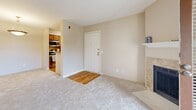 Located at 4801 S Wadsworth Blvd in Denver, Colorado, this one-bedroom, one-bathroom residence offers a thoughtfully organized single-floor layout with a warm, neutral aesthetic throughout. The living room serves as the heart of the home, featuring a tile-surround fireplace, plush carpeting, and a glass door that opens directly onto a private balcony, allowing natural light to fill the space. Adjacent to the living room, the dining area connects seamlessly to the kitchen, which is equipped with stainless steel appliances, wood-toned cabinetry, and hardwood-style flooring. The spacious primary bedroom includes a ceiling fan, a large window with exterior views, and access to a walk-in closet with built-in shelving. A second closet provides additional storage. The bathroom features a full tiled tub-shower combination, a warm wood-toned vanity with ample cabinet storage, and tile flooring. A dedicated utility and laundry area adds everyday convenience. Soft, neutral wall tones and carpeting run throughout the main living spaces, creating a cohesive and inviting atmosphere well-suited for comfortable Denver living.
