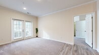 Located at 593 Rolling Marsh Ln in Hardeeville, South Carolina, this single-story, 4-bedroom, 2-bathroom home offers a practical and comfortable layout. The open living area features a seamless transition between carpet and light wood-look vinyl flooring, crown molding, and French doors that invite natural light and provide outdoor access. The kitchen is a standout feature, boasting rich cherry-toned cabinetry, granite-look countertops, stainless steel appliances including a range, microwave, and refrigerator, and a breakfast bar that connects to the living space. The spacious primary bedroom offers generous room to accommodate a full suite of furniture. All bedrooms are finished with plush carpet and neutral warm-toned walls, creating a calm and inviting atmosphere. The two bathrooms are well-appointed, with one featuring a tiled soaking tub/shower combination and the other offering a shower with curtain enclosure, both with wood-look vinyl flooring. A connecting hallway links the bedroom wing to the main living areas. Throughout the home, clean white trim and soft beige walls maintain a cohesive, move-in-ready aesthetic suited for comfortable everyday living.