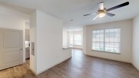This single-story residence in Houston, TX (77396) offers a well-designed open layout with a clean, modern aesthetic throughout. Wood-look flooring extends across the living areas, complementing the crisp white walls and creating a warm, cohesive feel.

The main living area is generously sized, bathed in natural light from multiple large windows fitted with white horizontal blinds. A ceiling fan overhead adds comfort, while a bay-style window nook at the far end of the living space adds architectural character and additional brightness. A direct-access entry door with glass panel connects this area to the outdoors.

The kitchen is thoughtfully appointed with granite countertops, gray shaker-style cabinetry, a white subway tile backsplash, and stainless steel appliances including an electric range, over-the-range microwave, and refrigerator. A peninsula counter provides a seamless transition to the living and dining areas.

The bedroom is spacious with its own ceiling fan and window overlooking the exterior, offering a quiet and comfortable retreat. The bathroom features a dual-sink vanity with granite countertops, a large mirror, and stylish brushed nickel fixtures. A conveniently located in-unit laundry closet is accessible directly from the bathroom, adding everyday practicality to the space.