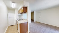 This one-bedroom, one-bathroom unit in Tulsa, Oklahoma, offers a efficiently organized single-floor layout that maximizes every square foot of available space. The open-concept design integrates the kitchen and living area into one cohesive zone, separated by a structural dividing wall that adds architectural definition without enclosing the space.

The kitchen is equipped with a white electric range, refrigerator, and dishwasher, complemented by warm wood-toned cabinetry overhead and below the countertop. A pass-through window connects the kitchen to the living area, enhancing the sense of openness. The kitchen features light wood-style flooring, while the living area transitions to neutral wall-to-wall carpeting. A ceiling fan provides air circulation in the main living space, and a textured ceiling is consistent throughout.

The bedroom is a carpeted, private room with direct access to the bathroom, which includes a tiled tub-shower combination, toilet, and light wood flooring. A dedicated closet provides storage. The unit's neutral color palette of whites and beiges creates a clean, functional environment suited for single occupancy or as a practical urban dwelling.