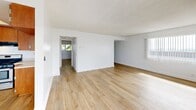 Located at 740 W 24th St in the San Pedro neighborhood of Los Angeles, this 2-bedroom, 2-bathroom single-floor unit offers a clean, functional layout with a bright and airy feel throughout. Light wood-style flooring runs continuously across all rooms, creating a cohesive and open atmosphere.

The living room is generously sized, featuring large windows and a sliding glass door that fills the space with natural light and provides access to an outdoor area. White walls and a textured ceiling complement the light tones of the flooring, giving the room a fresh, neutral character.

The kitchen is well-equipped with warm wood cabinetry spanning floor to ceiling, light countertops, stainless steel appliances including a gas range and dishwasher, and a dedicated overhead light fixture, making it both practical and visually inviting.

The primary bedroom is a comfortable retreat with a window framing views of palm trees, adding a Southern California touch. It is served by a full bathroom featuring a white vanity with a large mirror, built-in cabinetry for additional storage, and a tub-shower combination. A dedicated walk-in closet with built-in shelving and hanging rods provides ample storage. The second bedroom includes a sliding-door closet and benefits from the same consistent flooring and neutral palette found throughout the home.