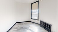 Located at 260 Sherbourne Street in Toronto's vibrant Cabbagetown neighbourhood, this one-bedroom, one-bathroom unit offers a thoughtfully utilized layout across a single floor. The space has been updated with modern finishes throughout, creating a clean and contemporary aesthetic.

The kitchen is a standout feature, outfitted with sleek white gloss cabinetry extending to the ceiling for maximum storage, dark countertops, a subway tile backsplash, and stainless steel appliances including a refrigerator and range. Light wood-style flooring runs through the main areas, complemented by bold dark baseboards that add a sharp visual contrast. An overhead chandelier-style light fixture adds a touch of character to the kitchen area.

The bedroom is a bright, cozy room featuring a large window with a roller blind that allows natural light to filter in. A cast iron radiator adds a charming, heritage touch, nodding to the building's classic character. The walls are finished in crisp white, keeping the room feeling open and airy.

The bathroom is finished with classic white subway tile on the walls, neutral stone-look floor tiles, and a full bathtub, offering a clean and functional space. Overall, this unit blends modern renovations with subtle heritage details, making it a well-appointed option in central Toronto.