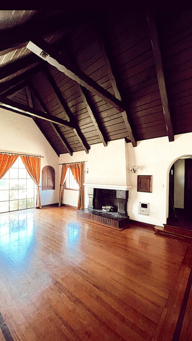 Living room with vaulted ceilings and brick fireplace - 902 E Bixby Rd