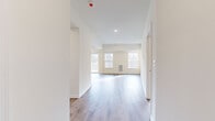 Located at 80 Cypress St in Ballston Lake, NY, this single-floor residence offers a bright, modern interior defined by clean lines and a neutral color palette throughout. The open-concept living and dining area is spacious and sun-drenched, featuring light-toned hardwood-style flooring, recessed lighting, and a tray ceiling detail that adds architectural dimension. Large windows and sliding glass doors lead to a private outdoor deck, inviting generous natural light and views of the surrounding wooded landscape. The kitchen is well-appointed with rich dark-toned cabinetry, light quartz countertops, a center island with bar seating, and a full suite of stainless steel appliances including a refrigerator with ice maker, range, and microwave. Bedrooms are carpeted for comfort and feature ample closet space, including sliding panel closet doors. The bathroom is finished with a dark wood vanity, white countertop, large mirror, and a tub-shower combination with brushed nickel fixtures. Recessed lighting is featured throughout, and the unit includes a wall-mounted HVAC unit in the main living area. The overall ambiance is clean, contemporary, and move-in ready, suited for modern residential living in a serene Ballston Lake setting.