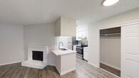 Located at 6305 Duck Creek Dr in Garland, TX, this single-floor residence offers a clean, modern aesthetic throughout its well-organized layout. The open-concept living area is anchored by a white brick fireplace with a raised hearth, serving as a focal point against neutral-toned walls and durable wood-look vinyl plank flooring. The space flows naturally into the kitchen, which is outfitted with white shaker-style cabinetry, white quartz countertops, a tiled backsplash, and a full suite of stainless steel appliances including a refrigerator, electric range, and dishwasher. A peninsula with a built-in sink connects the kitchen to the living area, enhancing the open feel. The bedrooms are finished with plush carpet and feature ceiling fans, ample natural light from windows, and generously sized closets. The bathrooms are updated with white vanities, brushed nickel hardware, and bright lighting fixtures. One bathroom includes a full tub-shower combination with white tile surround and overhead cabinetry for added storage. The textured ceilings and neutral color palette throughout contribute to a cohesive, move-in-ready interior that balances comfort and practicality.