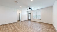 Located at 101 S Dean Ave in Raymore, MO, this well-appointed single-story home offers three bedrooms and two bathrooms within a thoughtfully designed open-concept floor plan. Light-toned luxury vinyl plank flooring flows throughout the main living areas, complementing the clean white walls and modern aesthetic. The spacious living room features a ceiling fan with recessed lighting and large windows fitted with blinds that invite abundant natural light. The contemporary kitchen is a standout, showcasing light wood cabinetry, a white subway tile backsplash, sleek quartz-style countertops, and a full suite of stainless steel appliances including a side-by-side refrigerator, electric range, and built-in microwave. A peninsula island with an undermount sink adds both functionality and style. The primary bedroom offers generous proportions with plush carpeting and a double-door closet, while the additional bedrooms also feature carpet flooring and individual closets. The primary bathroom includes a walk-in shower with built-in shelving, while the second bathroom offers a full tub-shower combo. Both bathrooms feature light wood vanities with gray countertops and wood-look flooring, maintaining a consistent modern style throughout the home.