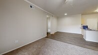 Located in Glendale, Arizona, this single-floor, two-bedroom, two-bathroom residence offers a well-organized layout designed for comfortable everyday living. The combined kitchen and living area forms the heart of the home. The kitchen is equipped with stainless steel appliances — including a refrigerator, range with microwave above, and dishwasher — complemented by light wood cabinetry, granite-style countertops, and wood-look flooring that extends into the dining and living areas. Crown molding adds a refined touch throughout the main living space, which also features a ceiling fan and sliding glass doors that open to a private balcony, allowing natural light to fill the room. Both bedrooms are carpeted and equipped with ceiling fans. The primary bedroom connects to its own closet, while a second closet provides additional storage. Each bathroom features wood-look flooring, a tub-shower combination, light wood vanity cabinetry, and granite-style countertops. A hallway connects the bedrooms and bathrooms, contributing to a practical and logical flow throughout the home. Wire shelving in the closets maximizes storage efficiency. The warm, neutral color palette throughout creates a cohesive and inviting atmosphere.