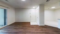 This 870-square-foot, single-floor unit at 1534 Teal Trce in Pittsburgh, Pennsylvania offers 2 bedrooms and 2 bathrooms in a well-organized layout. The living room is a standout space, featuring rich hardwood-style flooring, a white-surround fireplace with a classic mantel, and a sliding glass door that opens to a private balcony with outdoor views. Adjacent to the living room, the kitchen is equipped with white shaker-style cabinetry, stainless steel appliances including a refrigerator, electric range, and microwave, along with a peninsula countertop with an undermount sink — ideal for both cooking and casual dining. Tile flooring runs throughout the kitchen area. The primary bedroom spans 170 square feet and features soft carpeting, direct access to its own bathroom, and ample natural light. The second bedroom also offers carpet flooring, multiple windows, and a private exterior door. Both bathrooms include tub-shower combinations with tile surrounds and white vanities. A hallway and closet round out the unit. Textured ceilings are featured throughout, and the neutral color palette provides a clean, move-in-ready canvas throughout this Pittsburgh home.