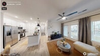 This thoughtfully designed single-story home in Carthage, NC offers a clean, modern aesthetic throughout its two bedrooms and two bathrooms. Light wood-look flooring flows seamlessly across the entire floor plan, lending warmth and continuity to every room.

The open-concept kitchen and dining area serves as the heart of the home, featuring white shaker cabinetry with matte black hardware, grey quartz-style countertops, white subway tile backsplash, stainless steel appliances, and a central island with pendant lighting — ideal for both cooking and entertaining.

The living room is bright and welcoming, with a ceiling fan, crown molding, and glass French doors that open to an outdoor area, filling the space with natural light and views of the surrounding landscape.

The primary bedroom is a comfortable retreat with a large window framing outdoor views, while the second bedroom offers a similarly serene setting. Both bathrooms are finished with white tile, clean fixtures, and black accents, including a full tub-shower combination.

A decorative hallway with patterned tile runner and large-scale artwork adds personality to the interior. Six closets — including walk-in options with wire shelving — provide exceptional storage. A dedicated laundry room and a single connecting hallway complete this efficiently laid-out home.