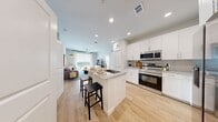 This well-appointed 2-bedroom, 2-bathroom residence at Broadstone Gulf Freeway in Houston, TX offers a thoughtfully designed single-floor layout with a clean, modern aesthetic throughout. Light wood-style flooring runs seamlessly across the open-concept living areas, enhancing the bright and airy feel of the space.

The kitchen serves as the heart of the home, showcasing crisp white shaker cabinetry, granite countertops with a tile backsplash, and a center island with a built-in sink and bar seating — ideal for both cooking and entertaining. Stainless steel appliances, including a French door refrigerator, gas range, microwave, and dishwasher, complete the culinary space.

The kitchen flows directly into the spacious living room, which is filled with natural light from large windows and a sliding glass door that opens to an outdoor area. The primary bedroom is generously sized, featuring a ceiling fan, large windows with outdoor views, and access to a well-appointed en-suite bathroom with granite vanity, a walk-in tiled shower, and a dedicated walk-in closet with wire shelving. The second bedroom and bathroom maintain the same quality finishes throughout.

A dedicated laundry room houses full-size Samsung washer and dryer units, adding everyday convenience to this polished, move-in-ready home.