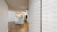 Located at 1767 Hermitage Blvd in Tallahassee, FL, this one-bedroom, one-bathroom unit offers a well-organized single-floor layout designed for comfortable, efficient living. The open-concept kitchen and living area form the heart of the home, featuring warm wood-style flooring that extends throughout the unit. The kitchen is equipped with stainless steel appliances — including a refrigerator and electric range — white cabinetry with a subway tile backsplash, and a peninsula breakfast bar that provides additional counter space and separates the kitchen from the living area. The living room is bright and open, highlighted by a ceiling fan and a large sliding glass door dressed with vertical blinds that allows natural light to pour in while offering outdoor views. The bedroom is a comfortable, well-lit space with a ceiling fan, a large window with blinds, and light wood-style flooring. The bathroom features a wide vanity with white cabinetry, a large mirror, and a bright light bar. A dedicated laundry room houses a full-sized washer and dryer, adding everyday convenience. Textured ceilings and neutral-toned walls are consistent throughout, creating a clean and cohesive aesthetic across the entire space.