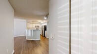 Located at 1767 Hermitage Blvd in Tallahassee, FL, this one-bedroom, one-bathroom unit offers a well-organized single-floor layout designed for comfortable, efficient living. The open-concept kitchen and living area form the heart of the home, featuring warm wood-style flooring that extends throughout the unit. The kitchen is equipped with stainless steel appliances — including a refrigerator and electric range — white cabinetry with a subway tile backsplash, and a peninsula breakfast bar that provides additional counter space and separates the kitchen from the living area. The living room is bright and open, highlighted by a ceiling fan and a large sliding glass door dressed with vertical blinds that allows natural light to pour in while offering outdoor views. The bedroom is a comfortable, well-lit space with a ceiling fan, a large window with blinds, and light wood-style flooring. The bathroom features a wide vanity with white cabinetry, a large mirror, and a bright light bar. A dedicated laundry room houses a full-sized washer and dryer, adding everyday convenience. Textured ceilings and neutral-toned walls are consistent throughout, creating a clean and cohesive aesthetic across the entire space.