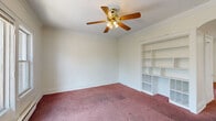 Located at 1769 Noble Rd in East Cleveland, Ohio, this single-floor, 3-bedroom, 1-bathroom unit offers a straightforward and functional layout. Crown molding runs throughout the carpeted living and bedroom areas, lending a classic architectural touch. The primary bedroom is generously sized, featuring a ceiling fan, a large triple-pane window that brings in natural light and outdoor views of surrounding greenery, and baseboard heating. An elegant arched doorway connects rooms and adds character to the interior.

The additional bedrooms are bright and well-proportioned, each with windows, carpet flooring, baseboard heating units, and closet access. The kitchen is equipped with warm wood cabinetry, a granite-style countertop, a stainless steel sink, a gas range, and a full-size refrigerator. Tile flooring and a window over the counter keep the kitchen practical and well-lit.

The bathroom includes a full bathtub and shower combination with wall surround panels and standard fixtures. A hallway connects the main rooms, contributing to an efficient and navigable floor plan. Throughout the unit, white walls and trim provide a clean, neutral backdrop, while baseboard heating ensures comfort across all rooms.
