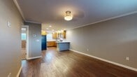 This single-floor residence offers a thoughtfully designed layout that maximizes functionality across its compact footprint. The open-concept kitchen and living area serves as the heart of the home, characterized by rich, dark hardwood-style flooring, crown molding, and neutral gray walls that create a cohesive, modern aesthetic throughout. Recessed lighting and flush-mount ceiling fixtures provide consistent illumination across the space.

The kitchen is well-equipped, featuring warm-toned wood cabinetry, granite countertops, a subway tile backsplash, a stainless steel gas range with a wall-mounted hood, and a peninsula that offers additional prep space and separates the kitchen from the living area. A window above the sink allows natural light to filter in.

The bedroom is a generously sized retreat finished with plush carpeting, a ceiling fan, a window with blinds, and two closets outfitted with built-in shelving rods, providing ample storage.

The bathroom is tastefully finished with large-format floor tiles, a vessel sink atop a wood vanity with granite counters, a full soaking tub, and a marble-style tiled surround. A dedicated entrance and closet complete the layout.