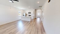 Located at 5121 Yonah Way in Knoxville, Tennessee, this thoughtfully designed two-story home offers three bedrooms, three bathrooms, and a spacious, functional layout across two floors. The main level provides a generous open-concept living and kitchen area bathed in natural light from multiple windows. The kitchen features white shaker cabinetry, stainless steel appliances including a refrigerator, microwave, and range, as well as a central island with a sleek countertop — ideal for both cooking and casual dining. Light wood-tone flooring flows seamlessly throughout, enhancing the home's bright, airy ambiance. The living area extends naturally from the kitchen, with a ceiling fan and a glass-paned door leading to the outdoors. A stylishly minimalist half bathroom on the main floor includes a pedestal sink with black metal accents. Upstairs, the primary bedroom is a comfortable retreat with a ceiling fan and walk-in closet featuring wire shelving. The primary bathroom impresses with a dual-sink vanity, black hardware accents, and a glass-enclosed tile shower. Additional bedrooms are well-proportioned with ceiling fans, ample natural light, and closet space. A dedicated laundry room with a full-size washer and dryer adds everyday convenience. Clean white walls and modern black fixtures tie the home's aesthetic together cohesively.