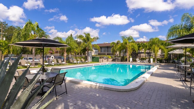 Enjoy a resort-style experience at our expansive sundeclk complete with lounge chairs, shaded tables, and tropical landscaping. Whether you're soaking up the sun or relaxing in the shade, this area offers the perfect retreat for our residents. - POSTE Winter Park