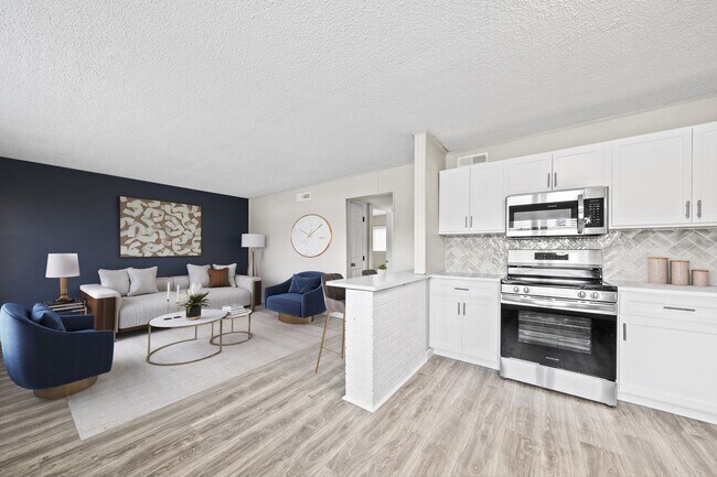 Cocine y entretenga a sus invitados en una cocina recientemente renovada con elegantes electrodomésticos negros y acabados modernos. - The Lynx Townhomes and Apartments